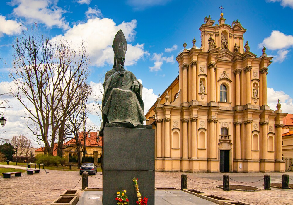 The monument to Cardinal Stefan Wyszyński and the Baroque Church of the Visitation Sisters , Warsaw